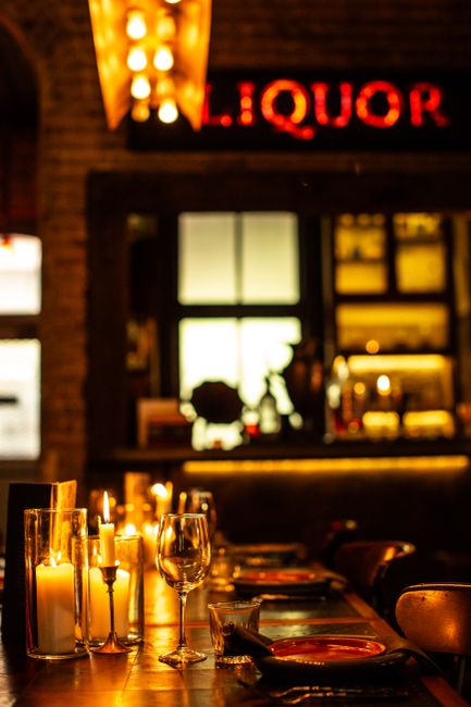 Candlelit bar counter with glasses in warm golden light